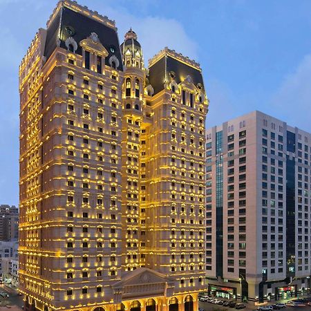 Royal Rose Abu Dhabi, A Curio Collection By Hilton Affiliated Hotel Exterior photo The image shows a beautifully illuminated building that has an ornate architectural style, featuring golden lights that highlight its elaborate facade. The building appears to be quite tall and is likely a hotel or a high-end residence. In the backgr