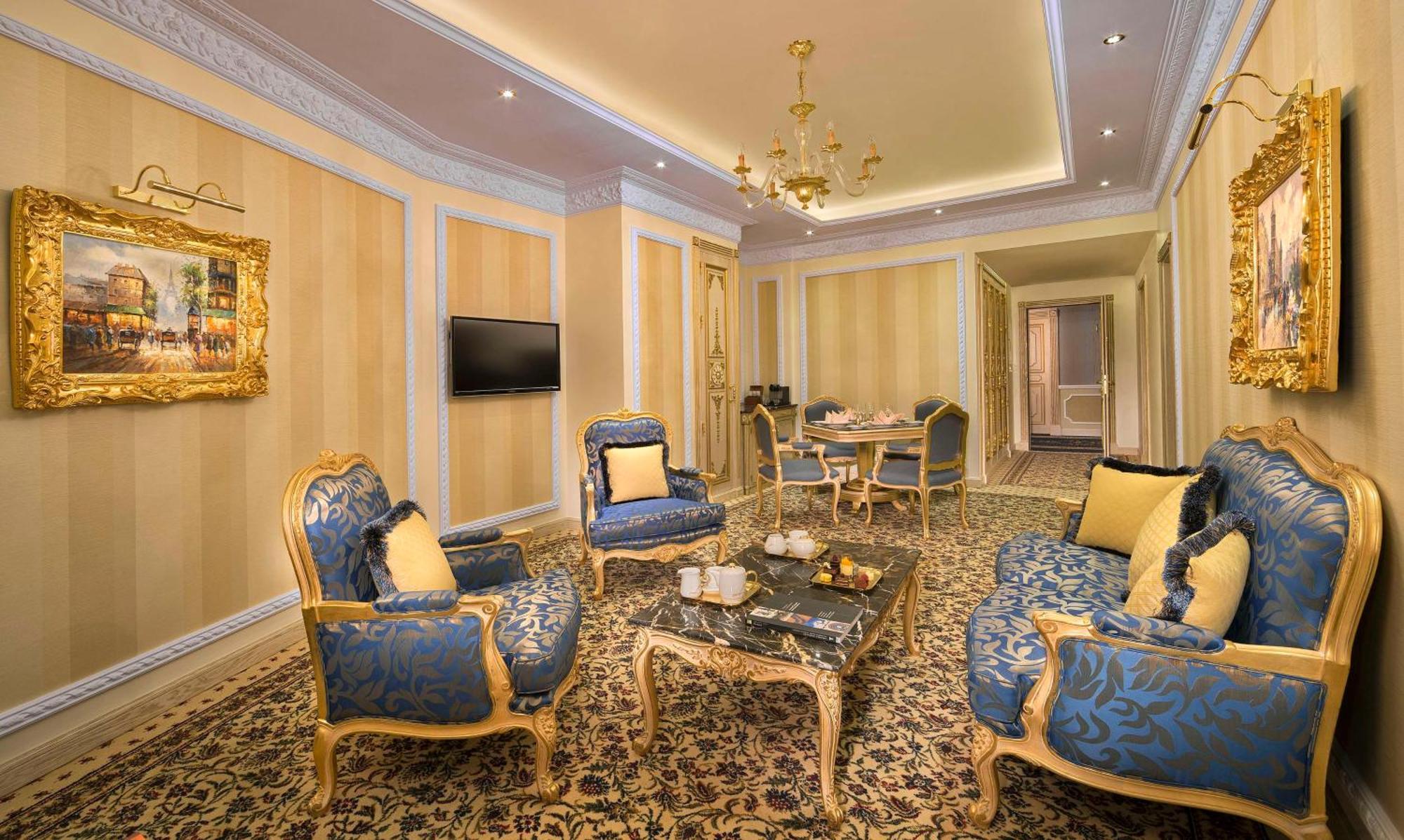 Royal Rose Abu Dhabi, A Curio Collection By Hilton Affiliated Hotel Exterior photo The photo shows a luxurious and elegantly furnished living room. It features ornate blue and gold chairs with cushions, a decorative coffee table in the center, and a plush carpet. The walls are painted in light tones with subtle patterns, and there 