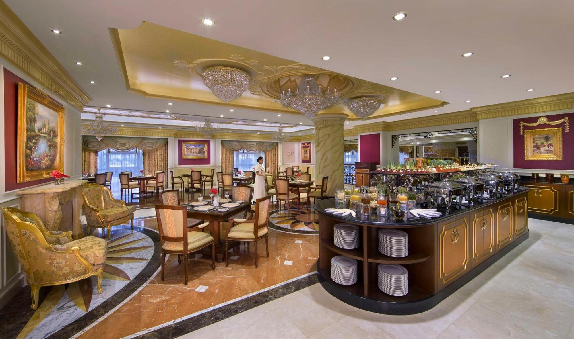 Royal Rose Abu Dhabi, A Curio Collection By Hilton Affiliated Hotel Exterior photo The image shows the interior of an elegant restaurant. It features a spacious dining area with several tables and chairs arranged neatly. The decor includes ornate chandeliers hanging from the ceiling and stylish lighting that adds a warm ambiance to