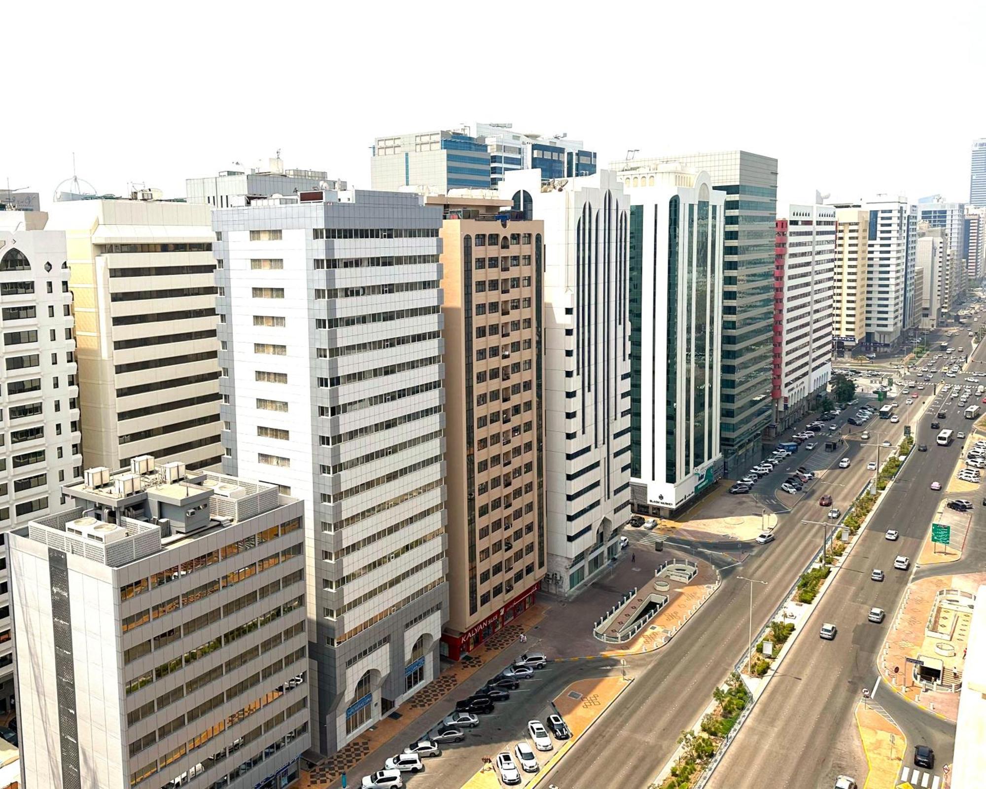 Royal Rose Abu Dhabi, A Curio Collection By Hilton Affiliated Hotel Exterior photo The photo showcases a cityscape featuring a variety of high-rise buildings and skyscrapers. The architecture appears modern, with a mix of designs, colors, and materials, including glass and concrete. The streets below are populated with cars, indica