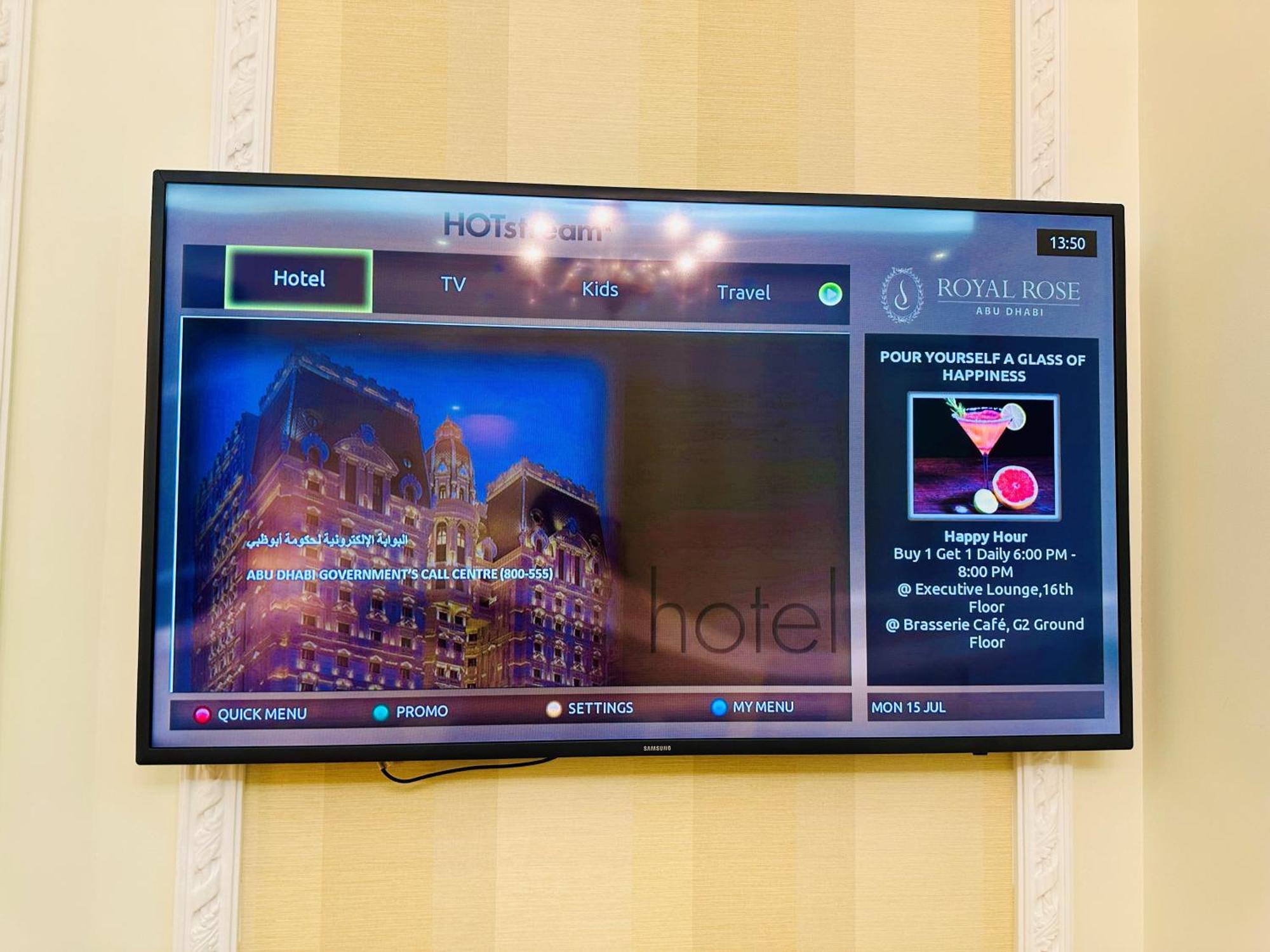 Royal Rose Abu Dhabi, A Curio Collection By Hilton Affiliated Hotel Exterior photo The photo shows a television screen displaying an interface for a hotel entertainment system. The left side features a picture of a hotel building lit up at night, along with text about hotel amenities. The right side presents options for guests, inc
